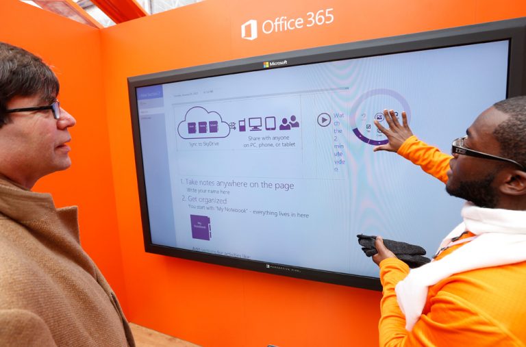 On a large touchscreen at the Office 365 Home Premium launch, people demonstrate how to use your fingers to move through pages and notes when you don't have a keyboard.