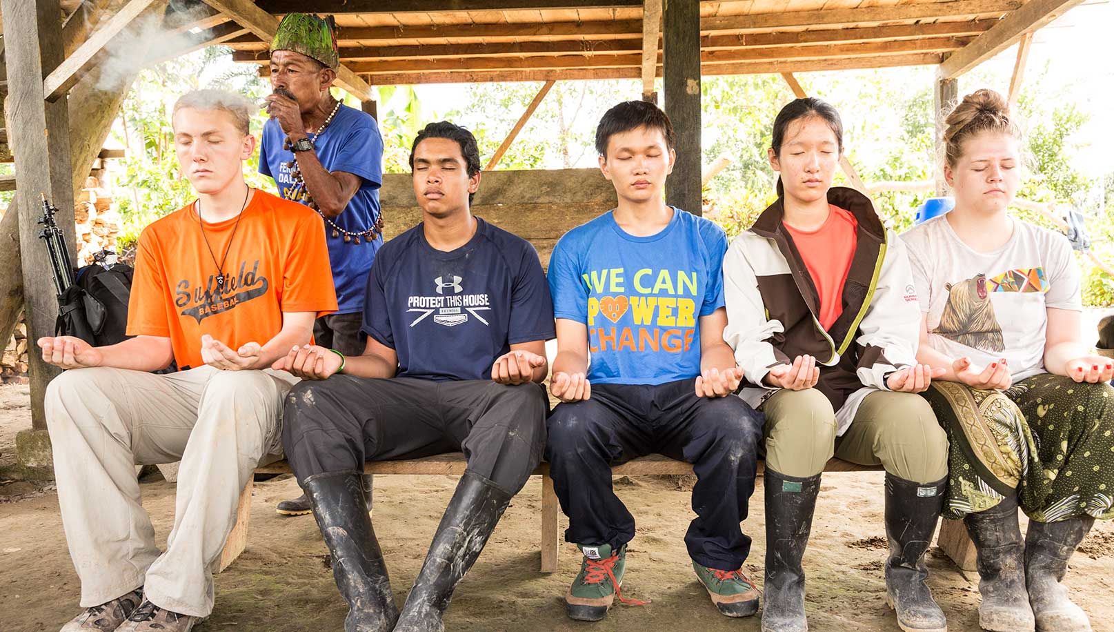 Co, al centro, vive la experiencia de una limpia por parte de un chamán ecuatoriano con otros huéspedes del Minga Lodge.