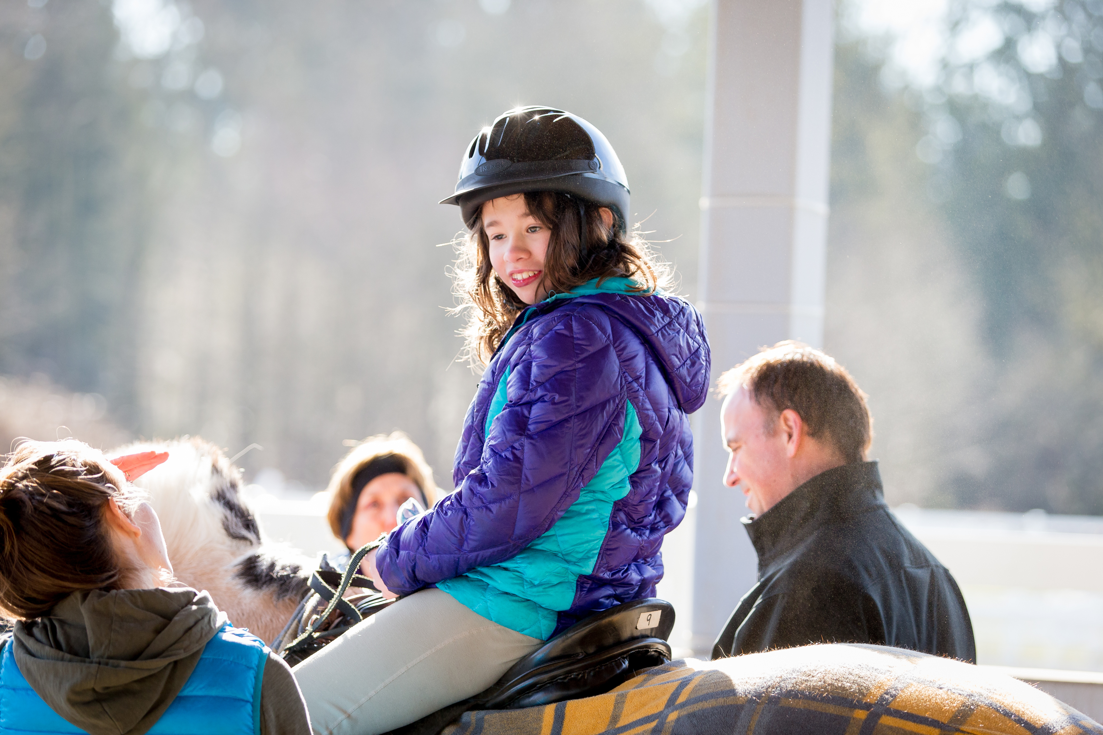Volunteers, including Jeff Gollnick of Microsoft, right, assist Sadie with her ride.