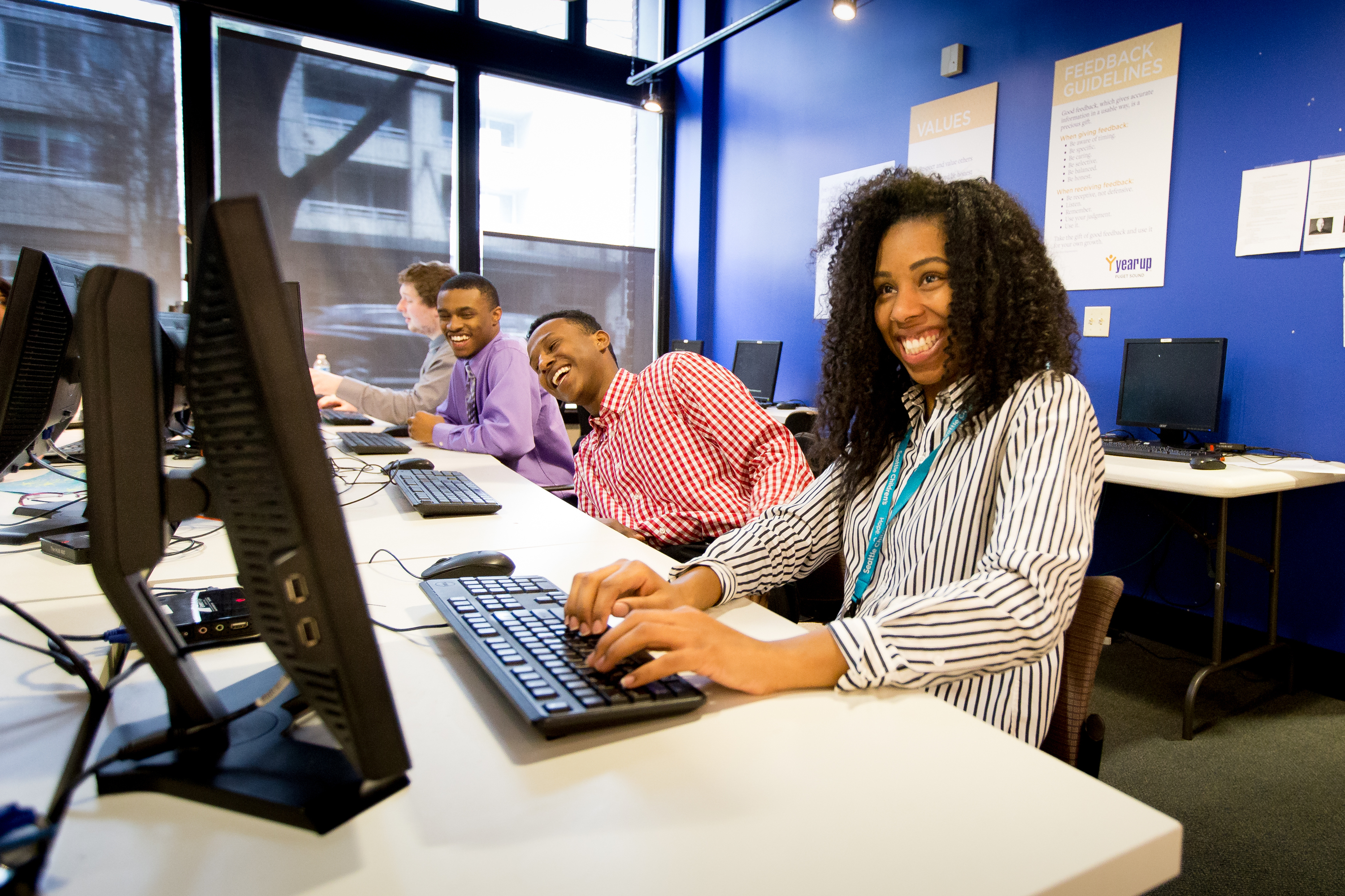 De'Shannon Nelson, right; Ahmed Sheileh, second from right; and Brian Hughes at Year Up Puget Sound, which helps young adults, ages 18 to 24.