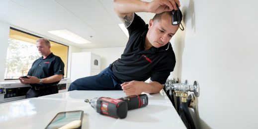 Richie Kay, service manager, and Danny Sanchez, lead technician for WASH Multifamily Laundry, on a service call.