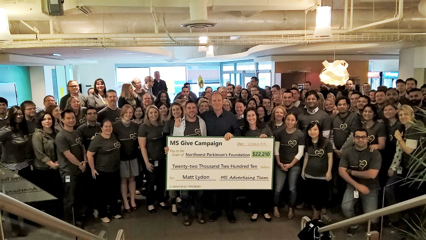 Matt Lydon is surrounded by employees who held a secret fundraiser to surprise him.