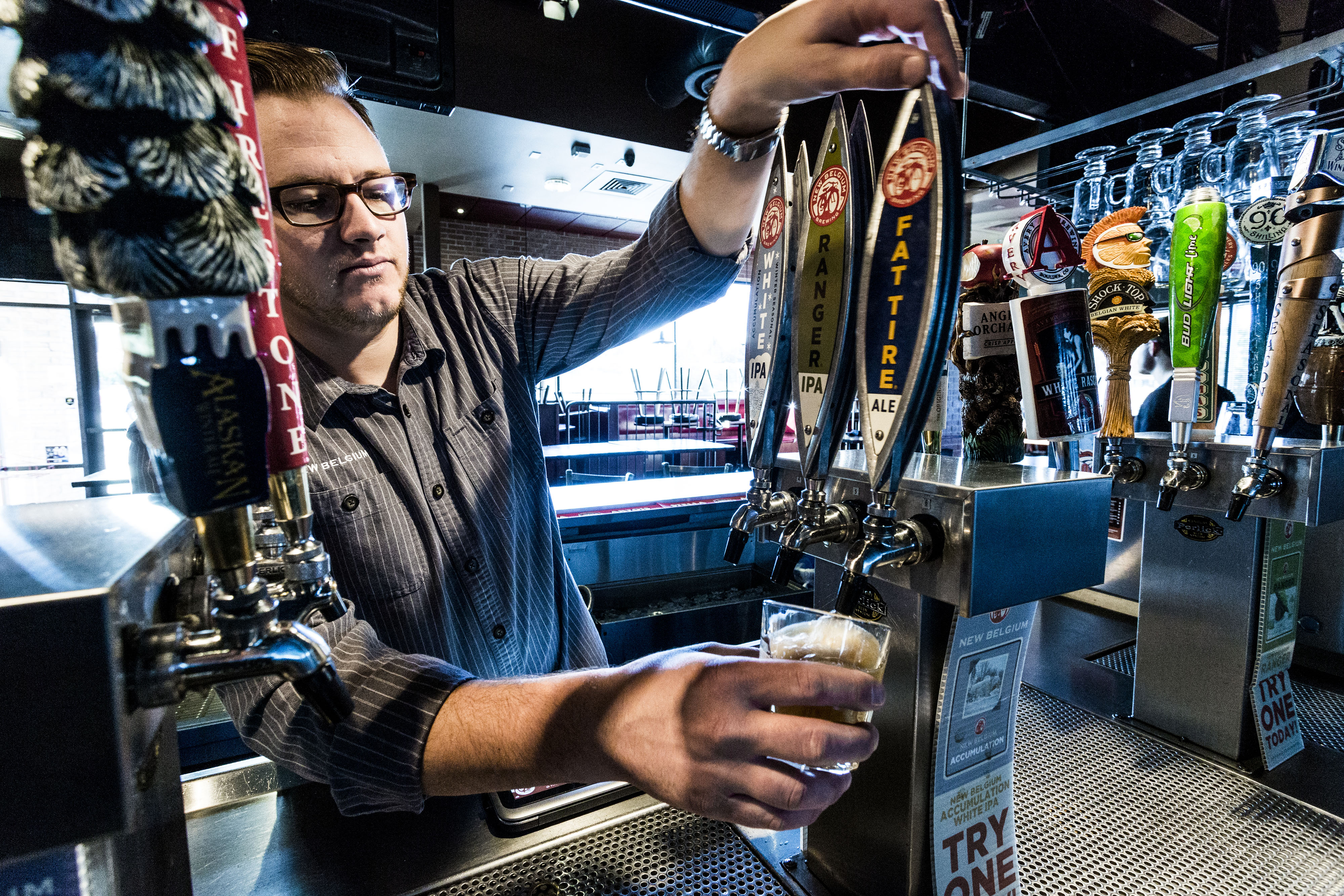 On a visit to one of his regular customers, Austin Whitaker takes a moment to taste test New Belgium’s product, making sure it meets his — and New Belgium’s — expectations.