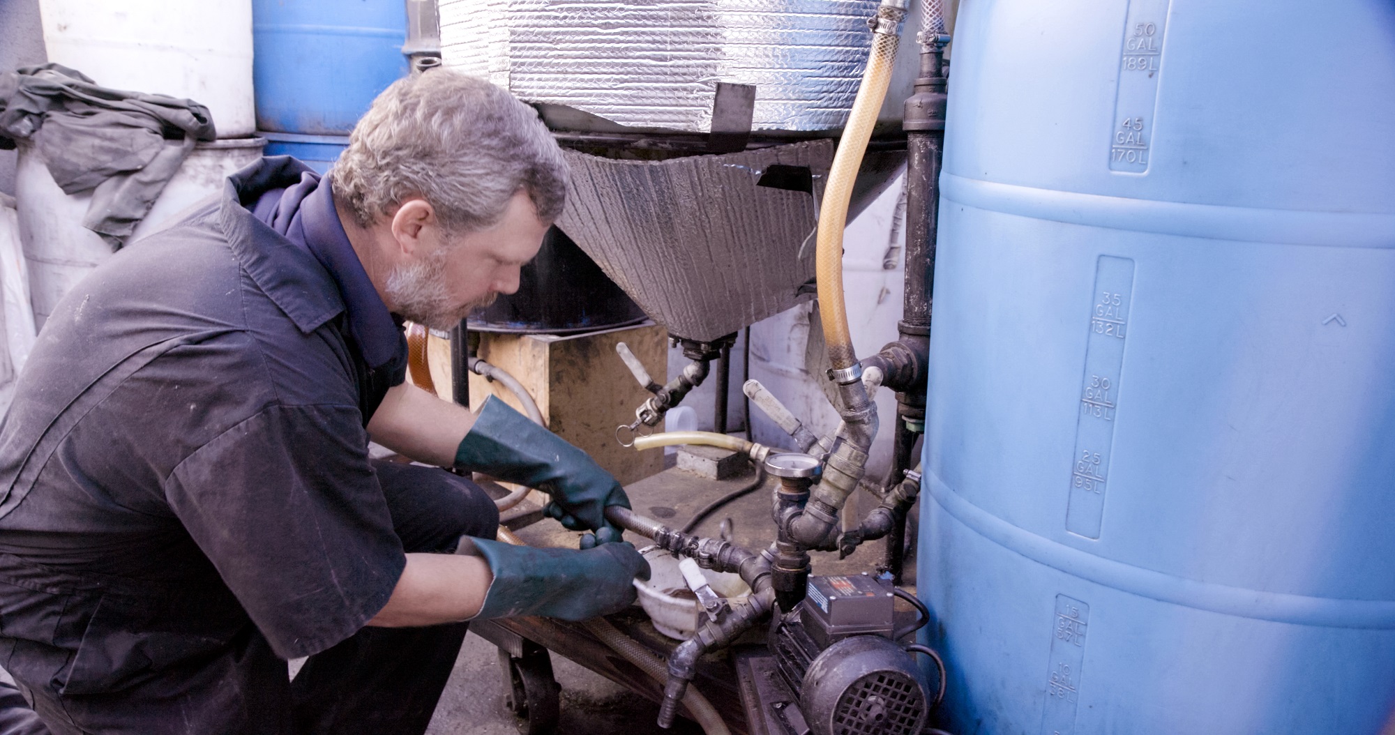 Marshall Dostal, in gloves, working on biofuel-making operation