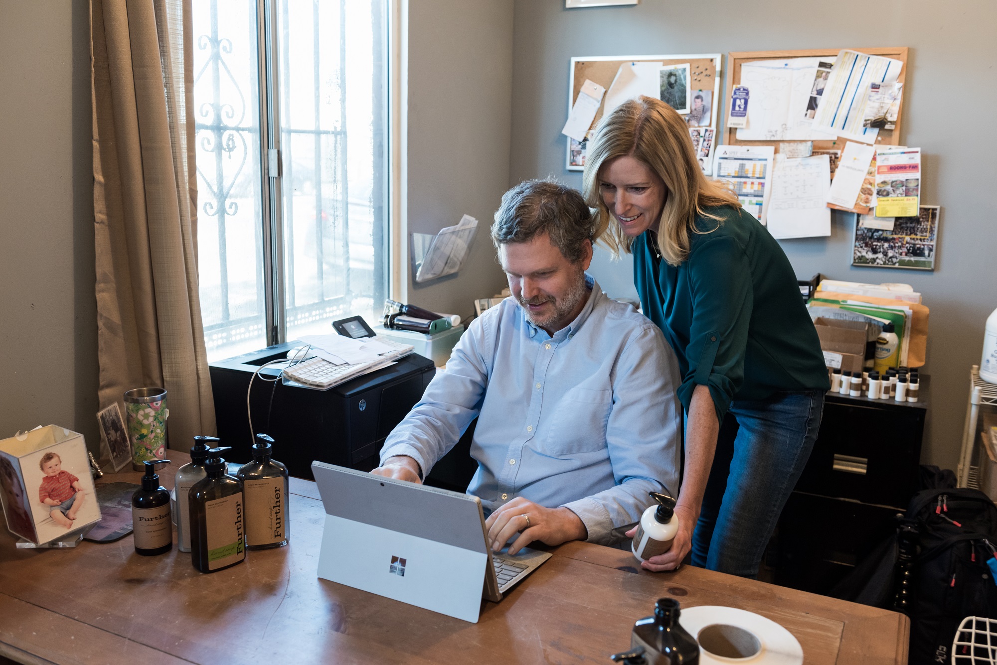 Marshall and Megal Dostal look at the screen of a Surface Pro 4 in an office