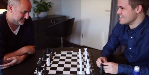 World chess champion Magnus Carlsen, right, with his manager Espen Agdestein, both seated near a chess set.