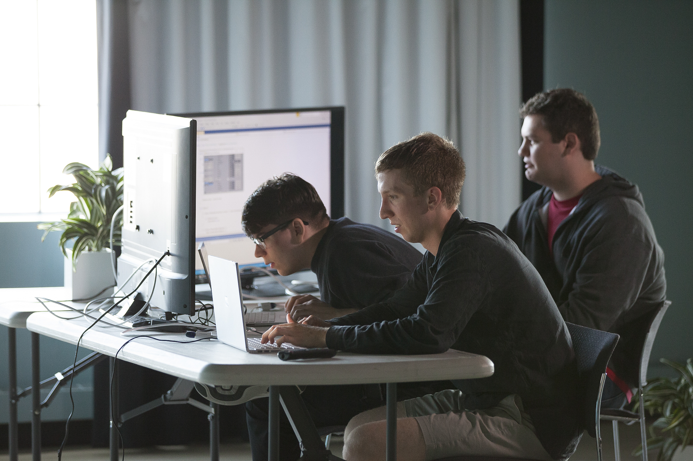 Game developers Connor Bell, left, Mason Palos and J.K. during a work session