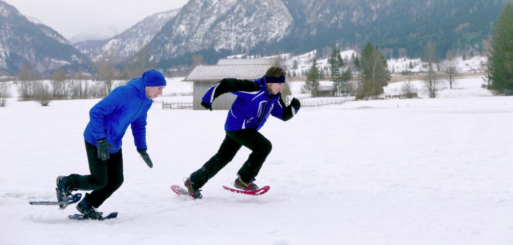 Photo of Anton Grotz and Daniele Bruno racing across a snowy farm with mountains in the background