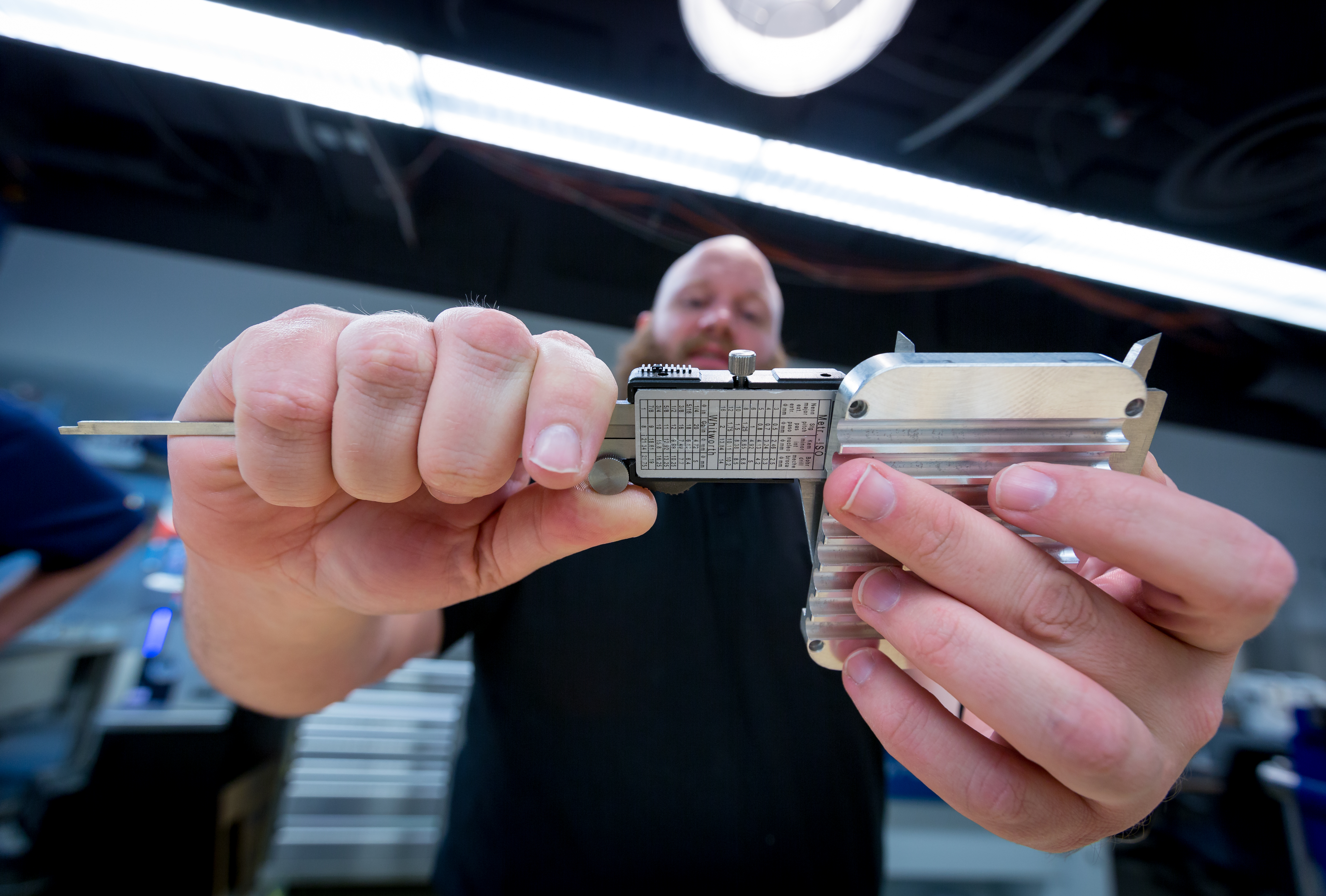 Barron Barnett measures an aluminum device case made in the lab.