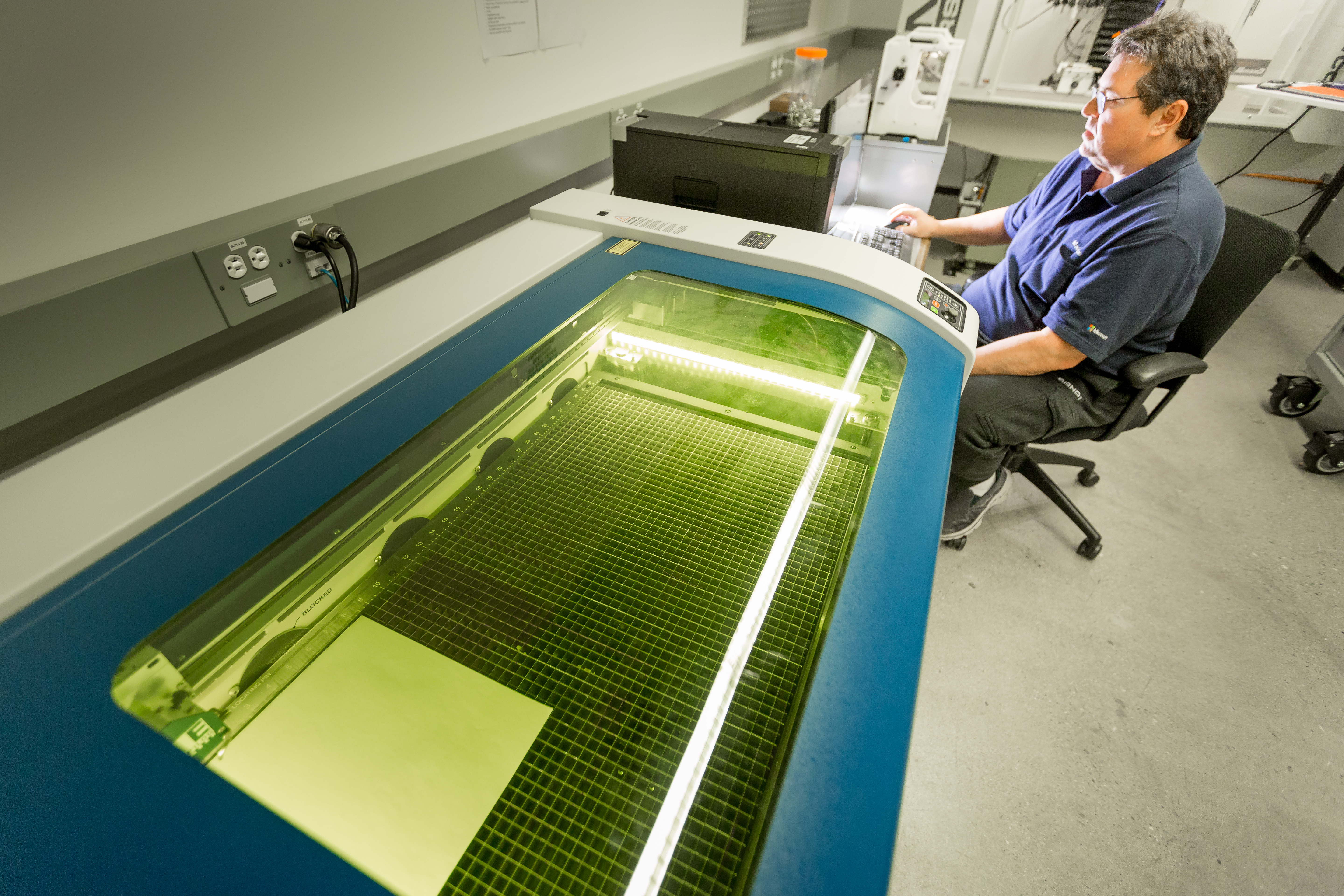 Sean Kelly operates the laser cutter.