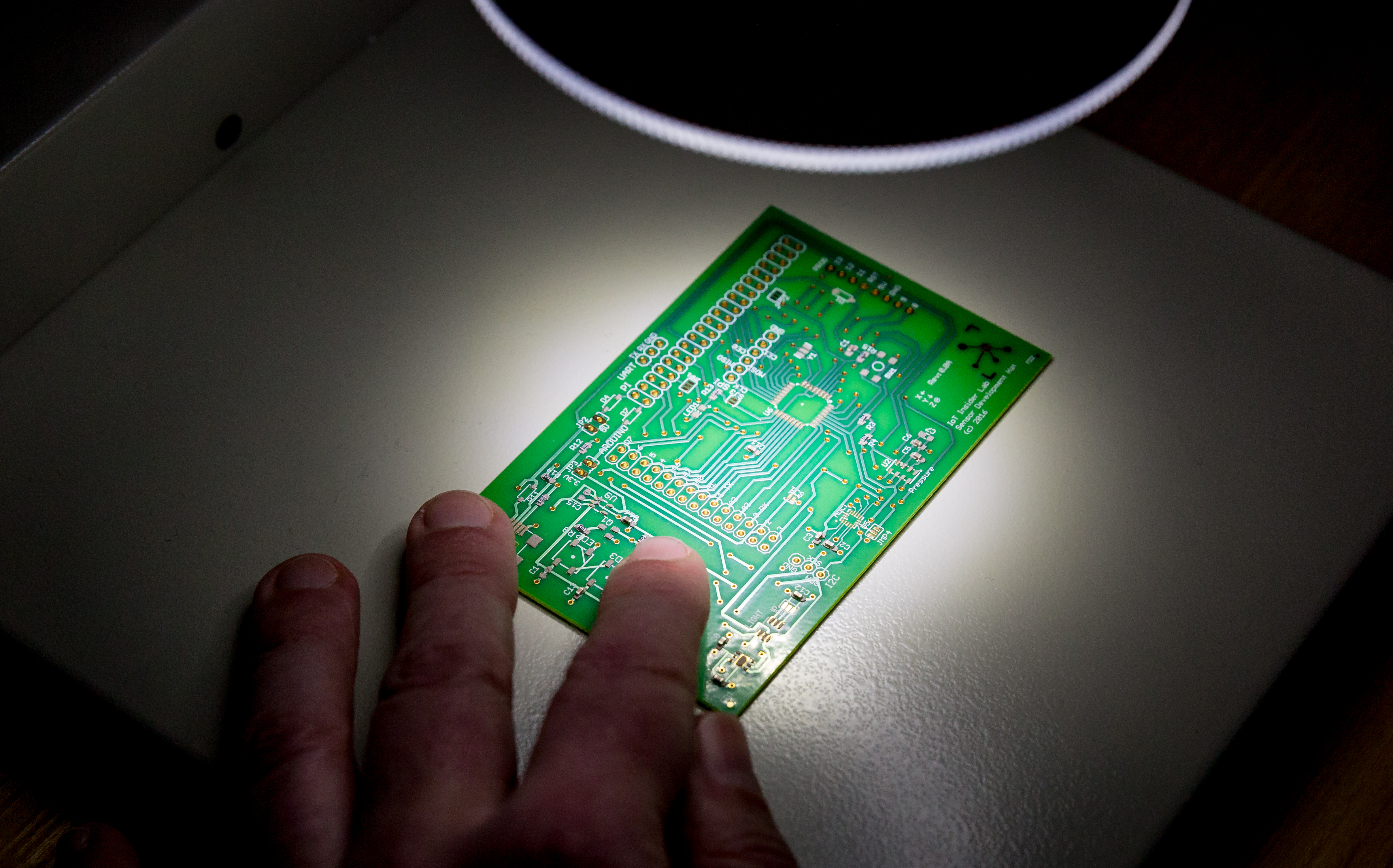 A PC board under the microscope in the testing room.