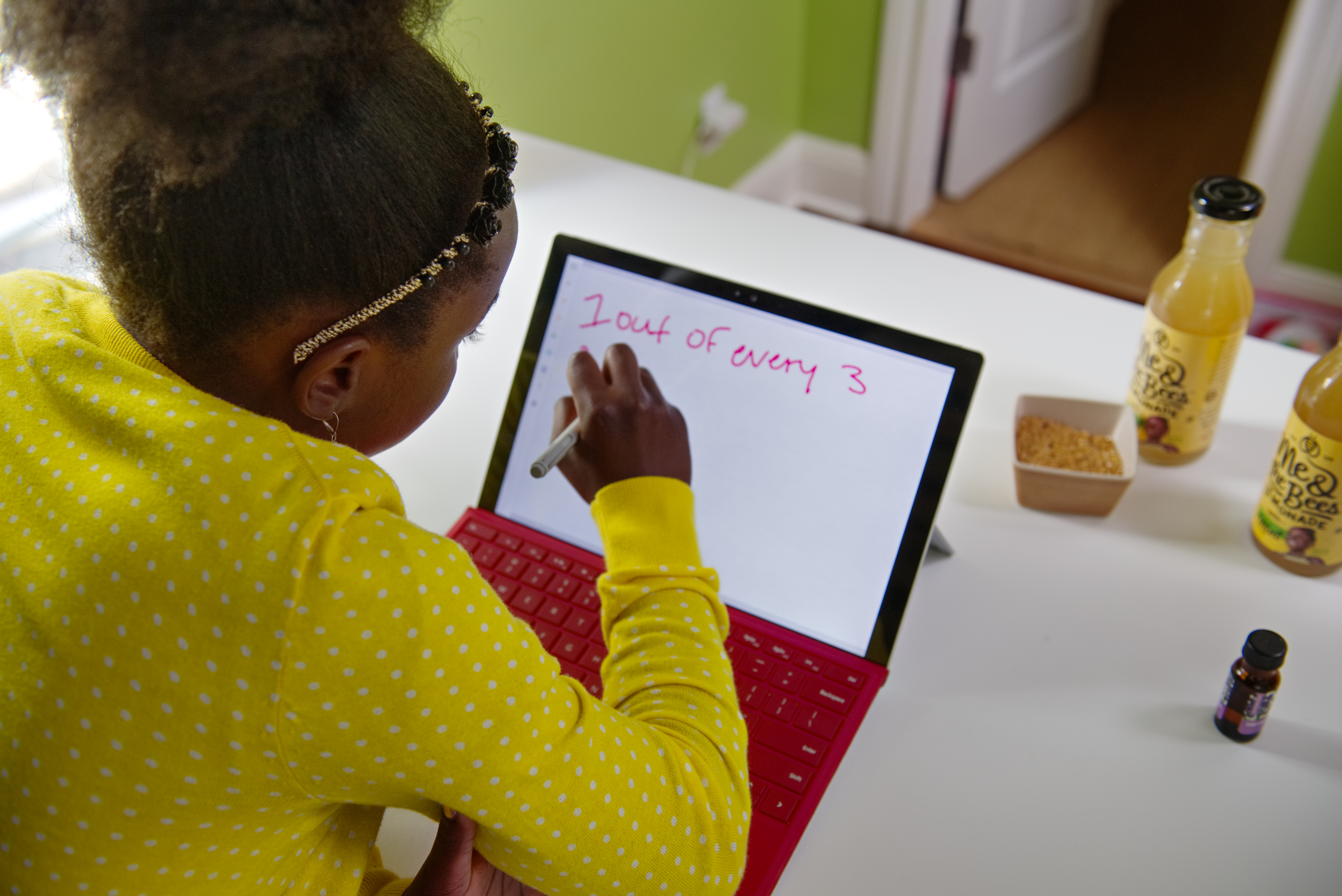 Photo taken from behind of girl writing on laptop