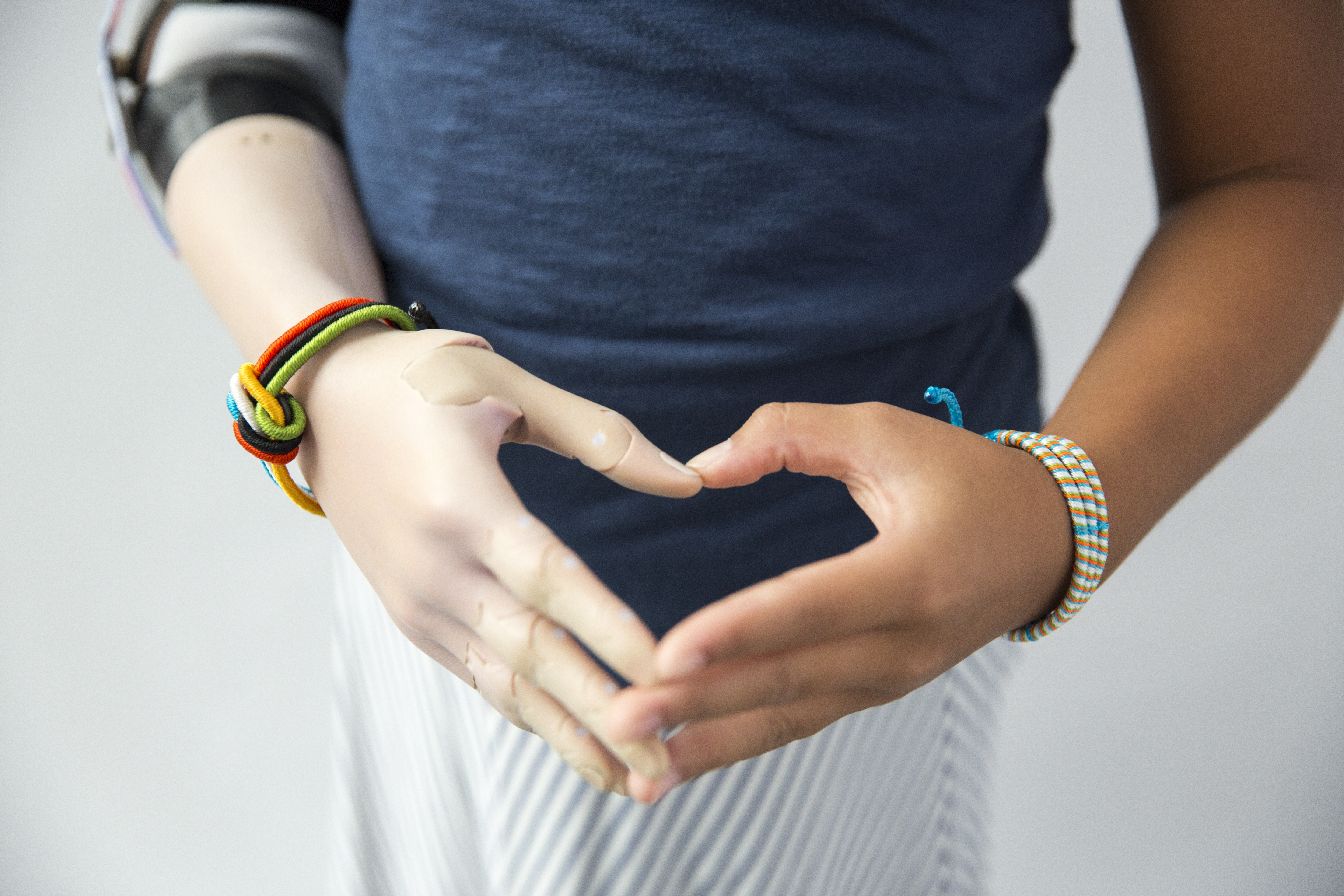 Momo Sutton forms a heart using her flesh and robotic hands.
