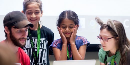 Participants at Girls Make Games camp gathered around a laptop