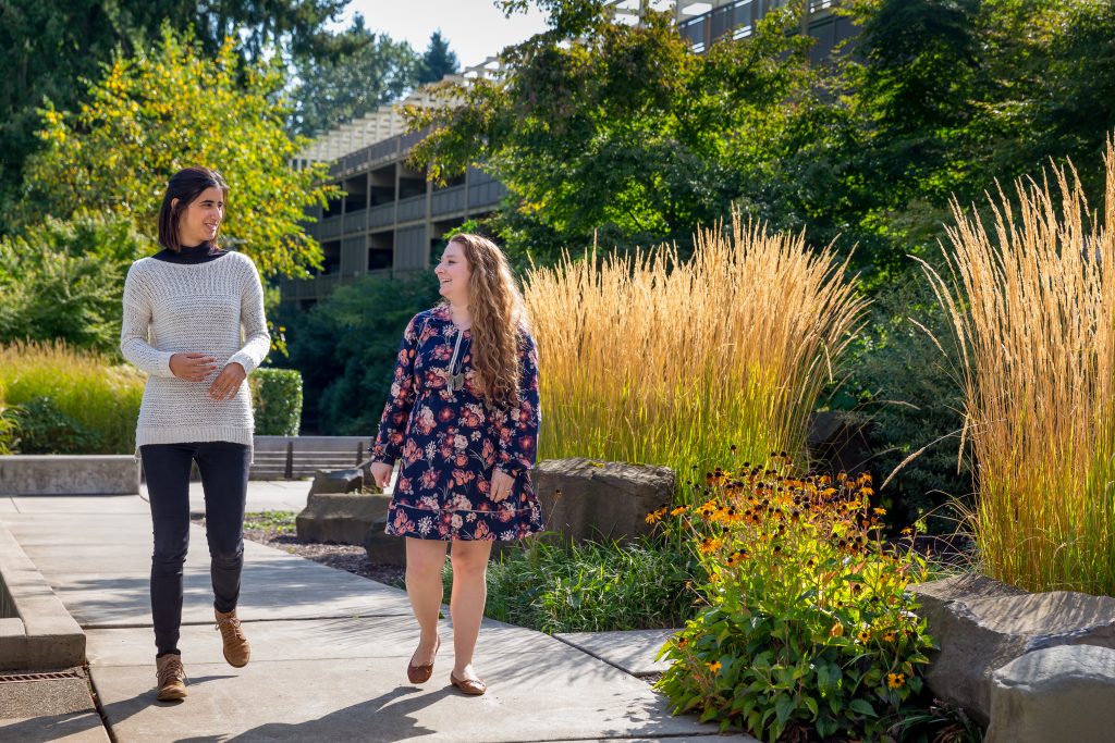 Edaena Salinas Jasso and Heather Shapiro take a walk on a garden path