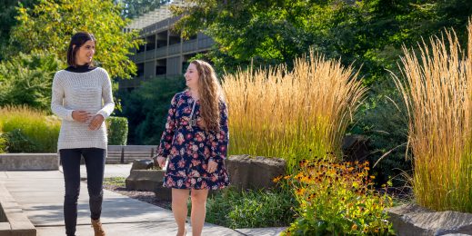 Edaena Salinas Jasso and Heather Shapiro take a walk on a garden path