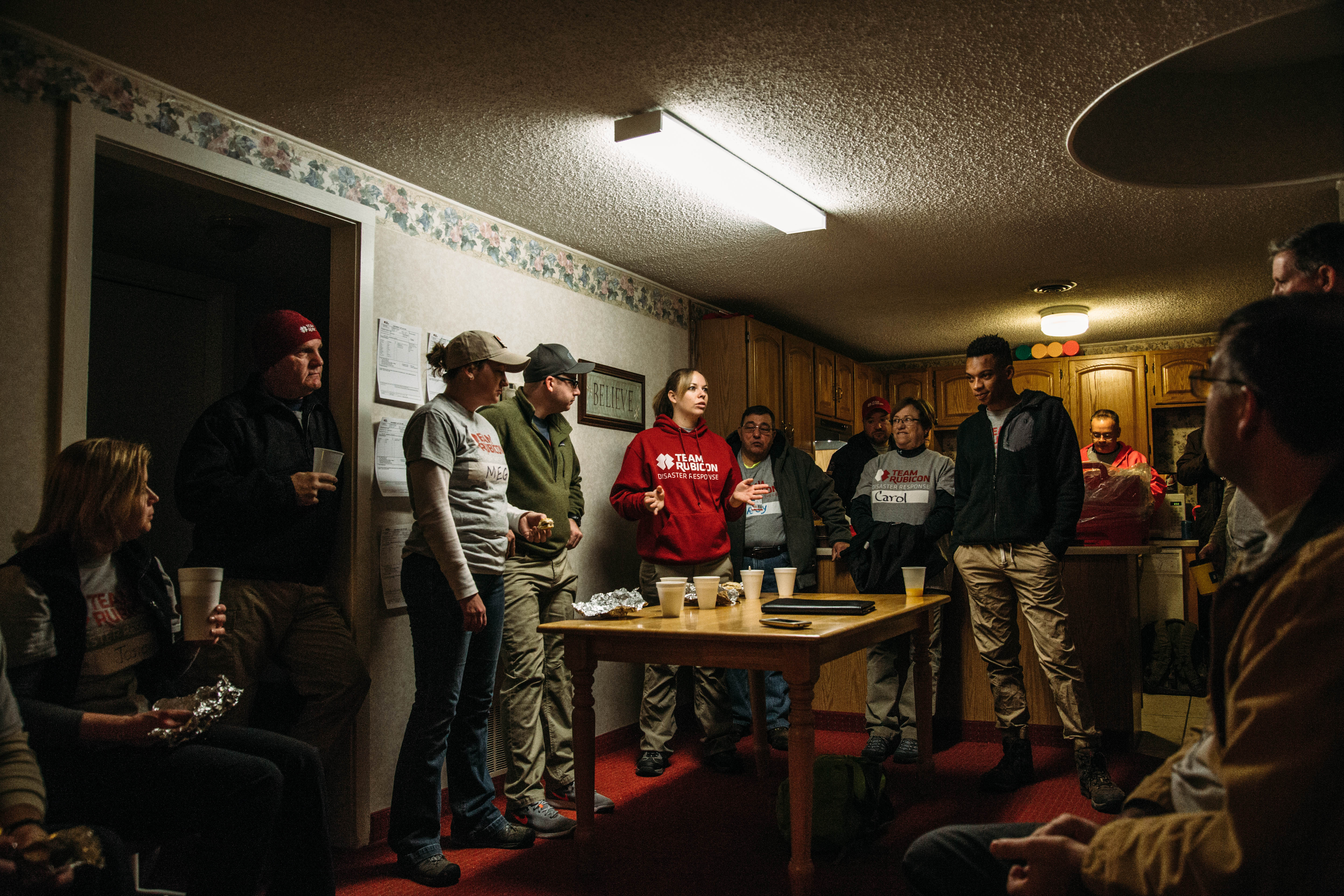 Photo of a group of volunteers standing and talking in someone's home