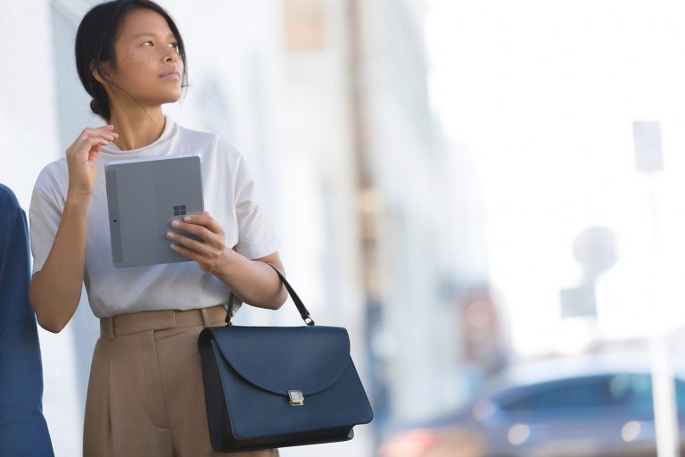 A woman holds a Surface Go