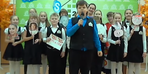 kids gather in front of a skype banner