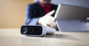 a man works on a surface device with an azure kinect in the foreground