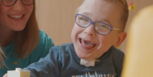 Nurse watches smiling boy play