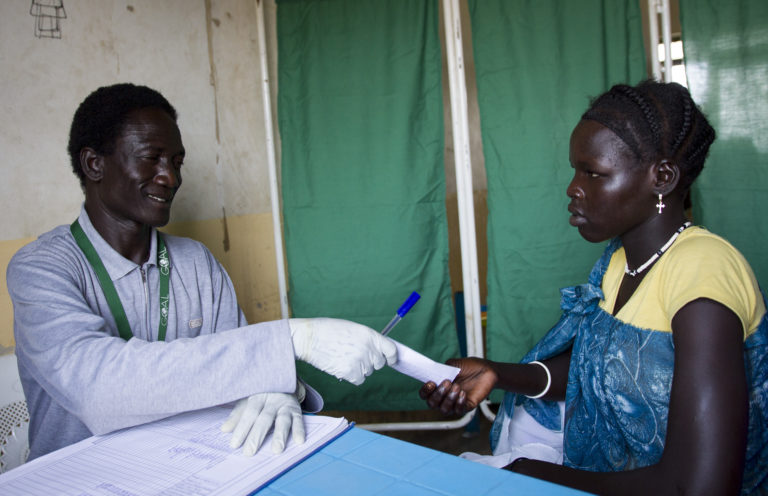Man hands a piece of paper to a woman.