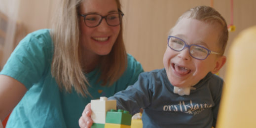 Nurses watches smiling boy play