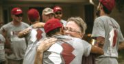 A young man wearing a Team Rubicon tshirt, hugs an older man.