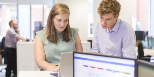 Two people at Mott MacDonald view a program on a laptop device