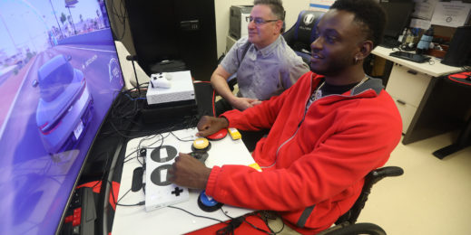 VA recreation therapist Jamie Kaplan, left, looks on as Mike Monthervil plays a game