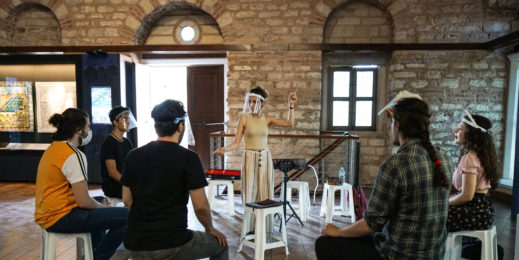 Woman performs music in front of a small group of people