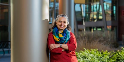 Woman standing next to a pillar