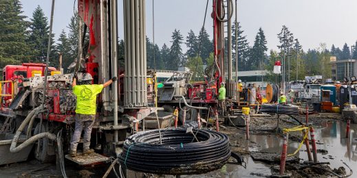 Construction workers and equipment on a muddy site