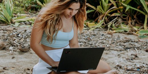 Woman working on a laptop computer on a beach