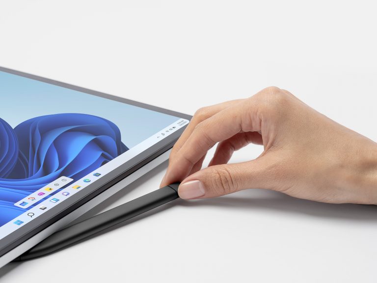 A person holding a black Surface Slim Pen 2