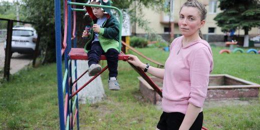 Woman stands with son at the playground