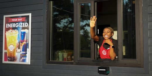 Woman at a drive-thru waves and smiles at a customer