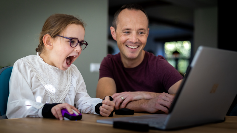 Father and daughter use laptop