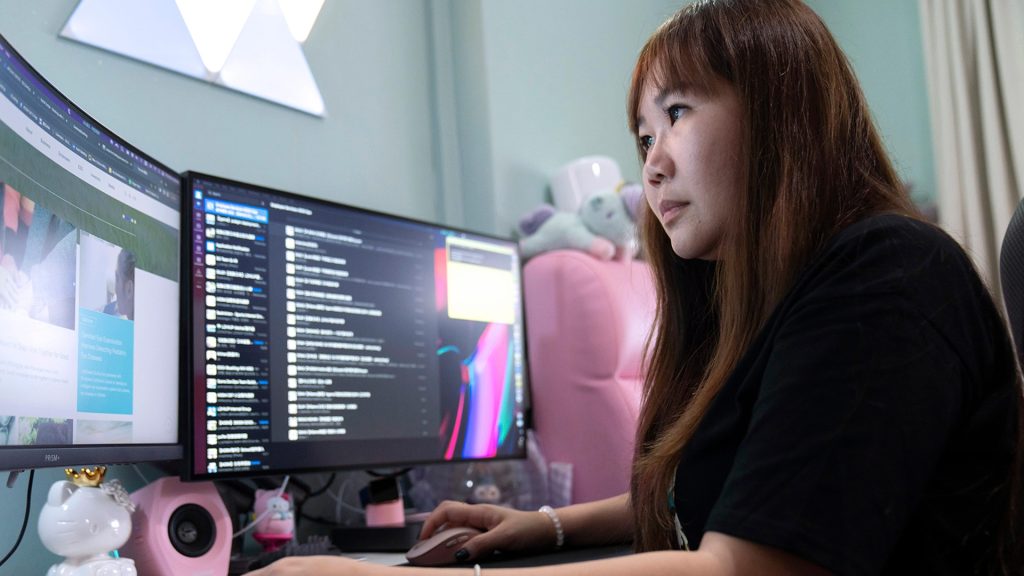 Woman sits at a desk using a computer