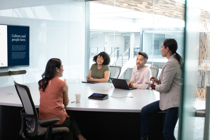 Equipo colaborando en una reunión de trabajo Microsoft