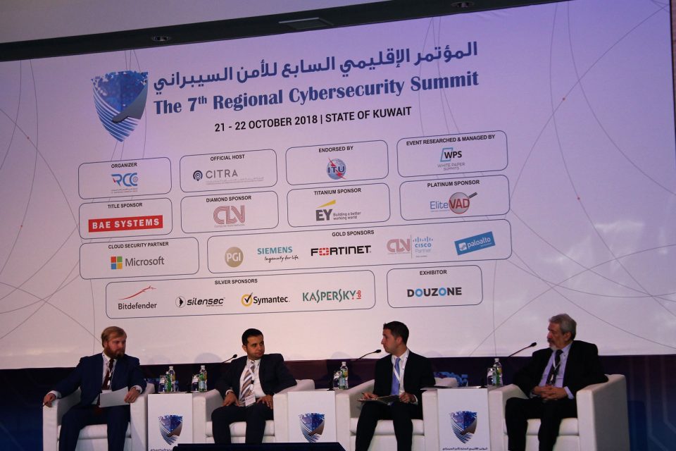 Four gentlemen on stage doing a panel discussion