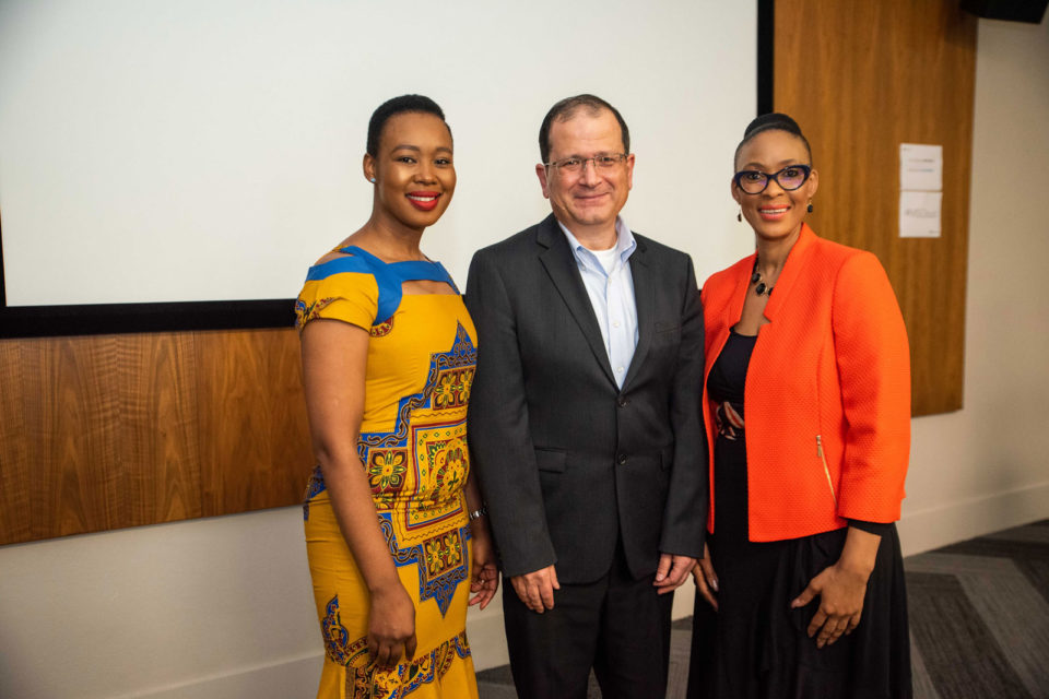 Two women and a man smiling at camera