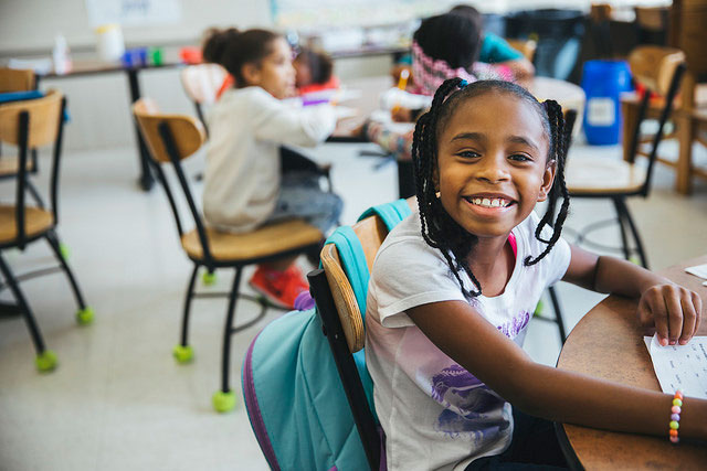 young girl sitting in a chair and smiling