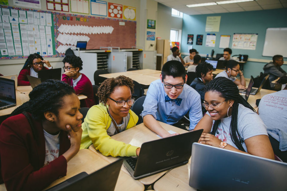 group of students working on computers and interacting