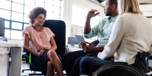 Business executive in wheelchair strategising with office colleagues