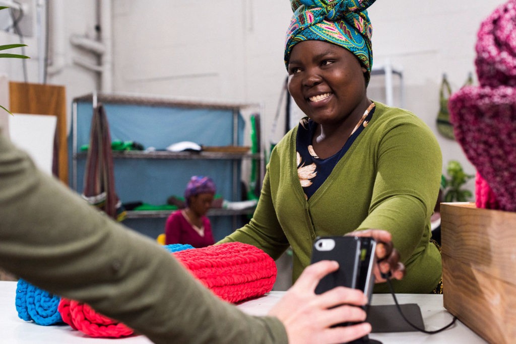 African woman processing payment with machine