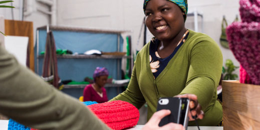 African woman processing payment with machine