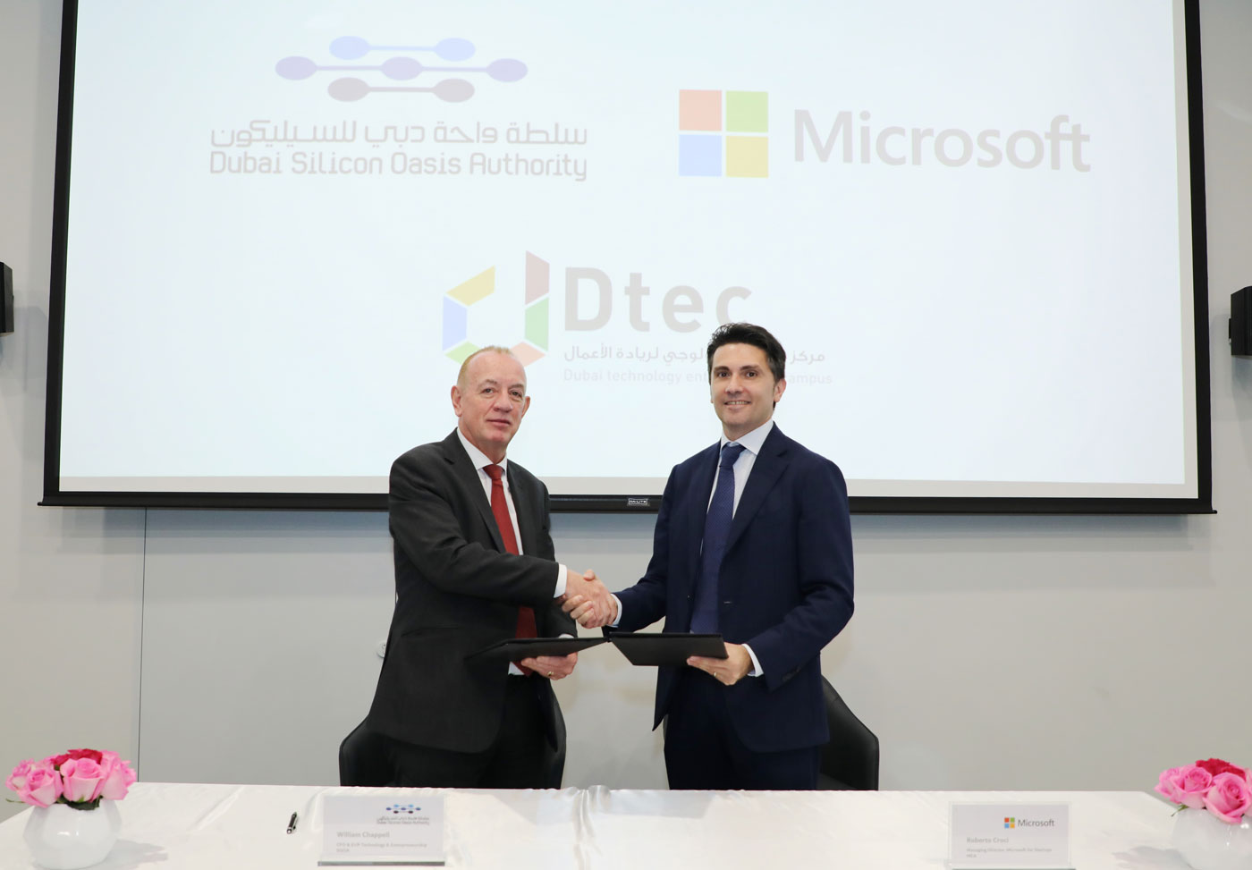 Two individuals shaking hands and holding contract