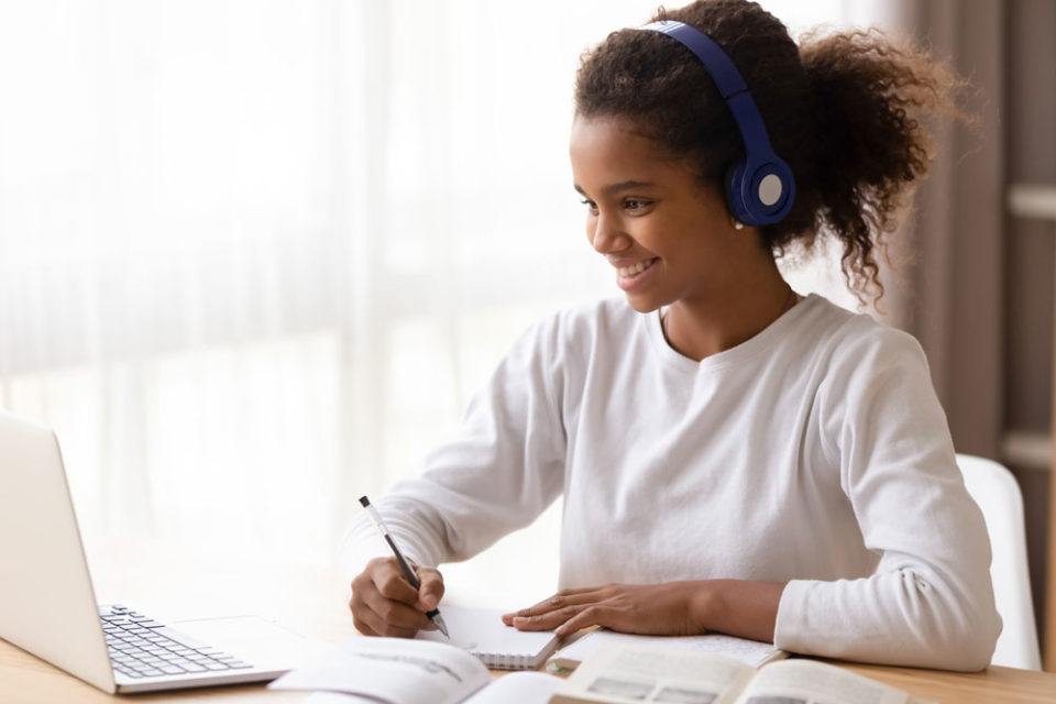 Teenage girl engaging in online coursework from home
