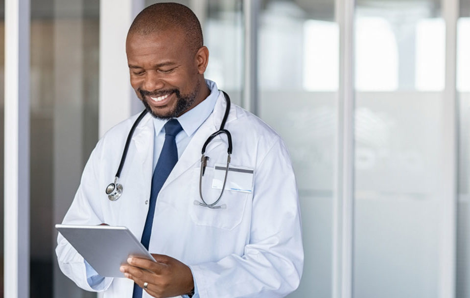 A medical doctor engaging with his medical team via a tablet device.
